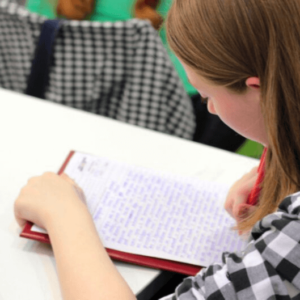 student writing in a notebook